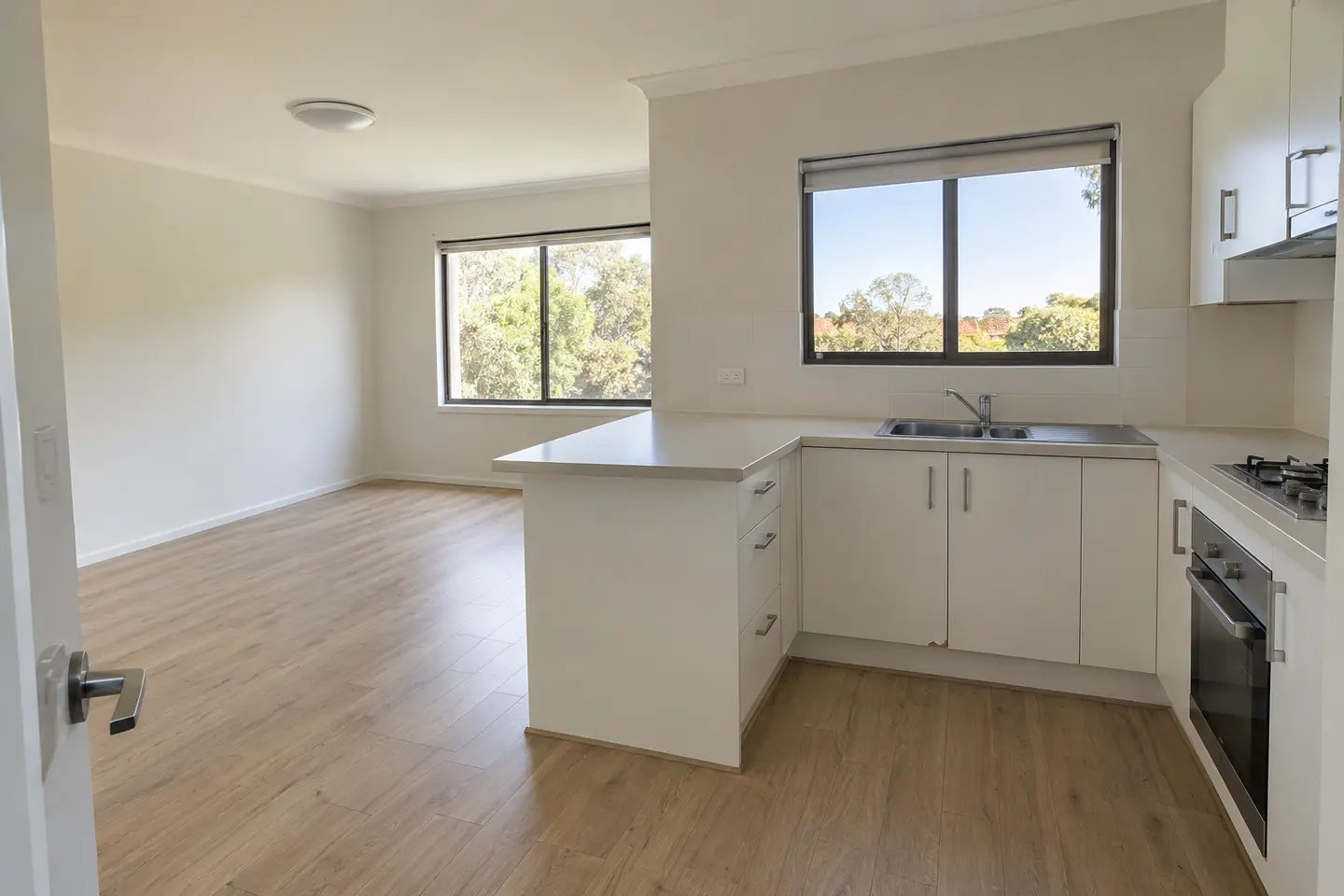 Wide demonstration photo of a clean rental kitchen and living area